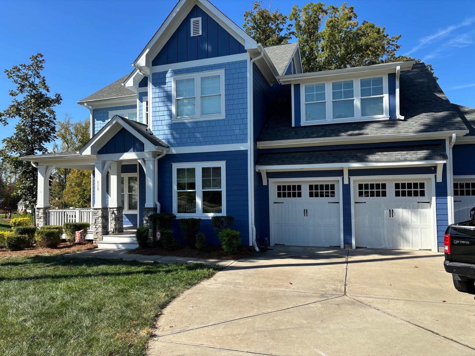 Blue two-story house with white trim from the Call One Painting project gallery